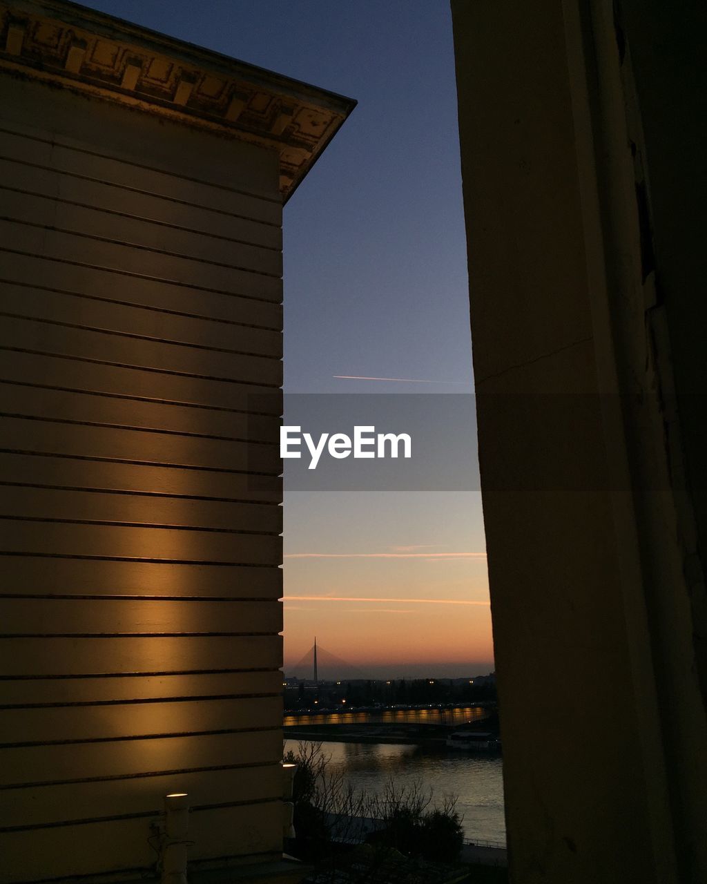 Building by river during sunset