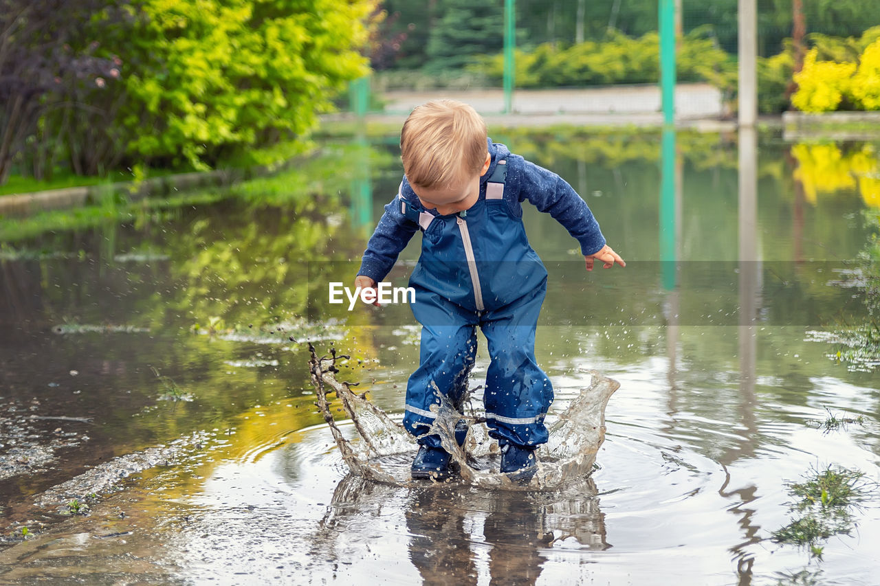 Full length of boy playing in lake