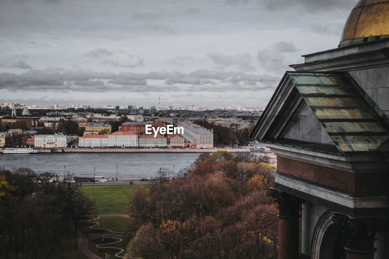 High angle view of buildings by river against sky