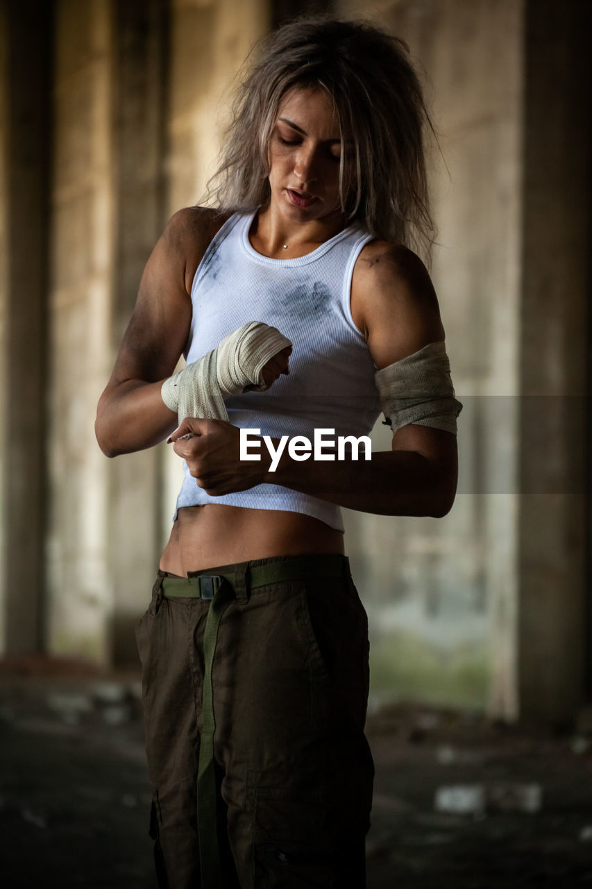 Female fighter wrapping bandage on hand