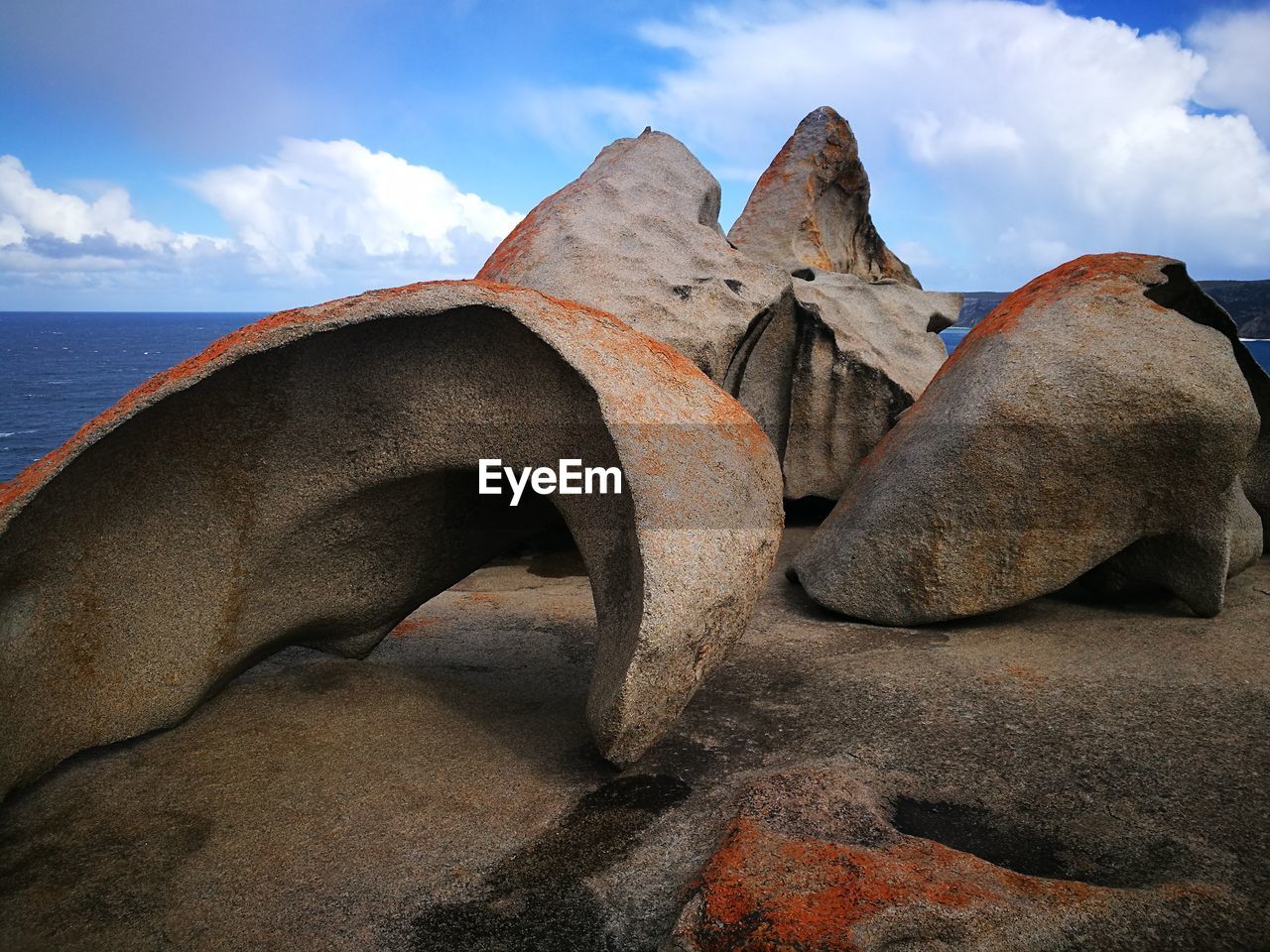 Scenic view of rocks on beach against sky