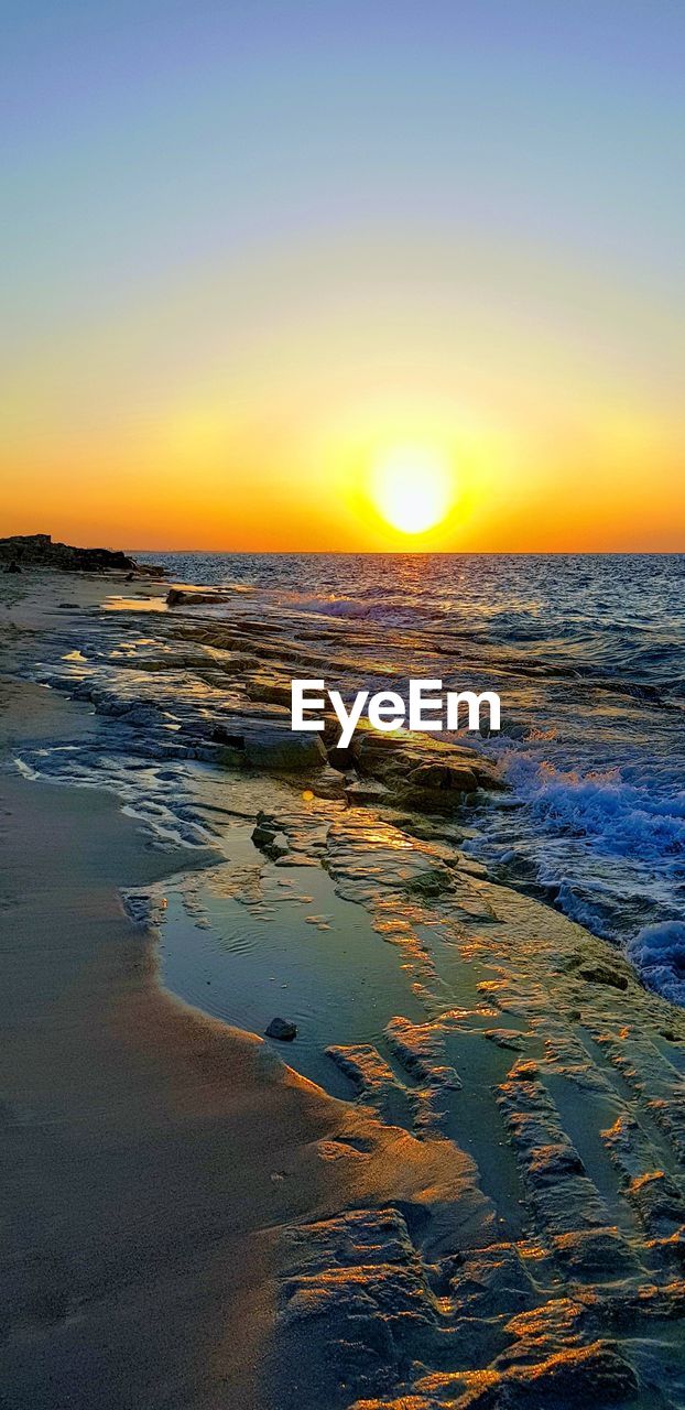 SCENIC VIEW OF BEACH AGAINST SKY DURING SUNSET