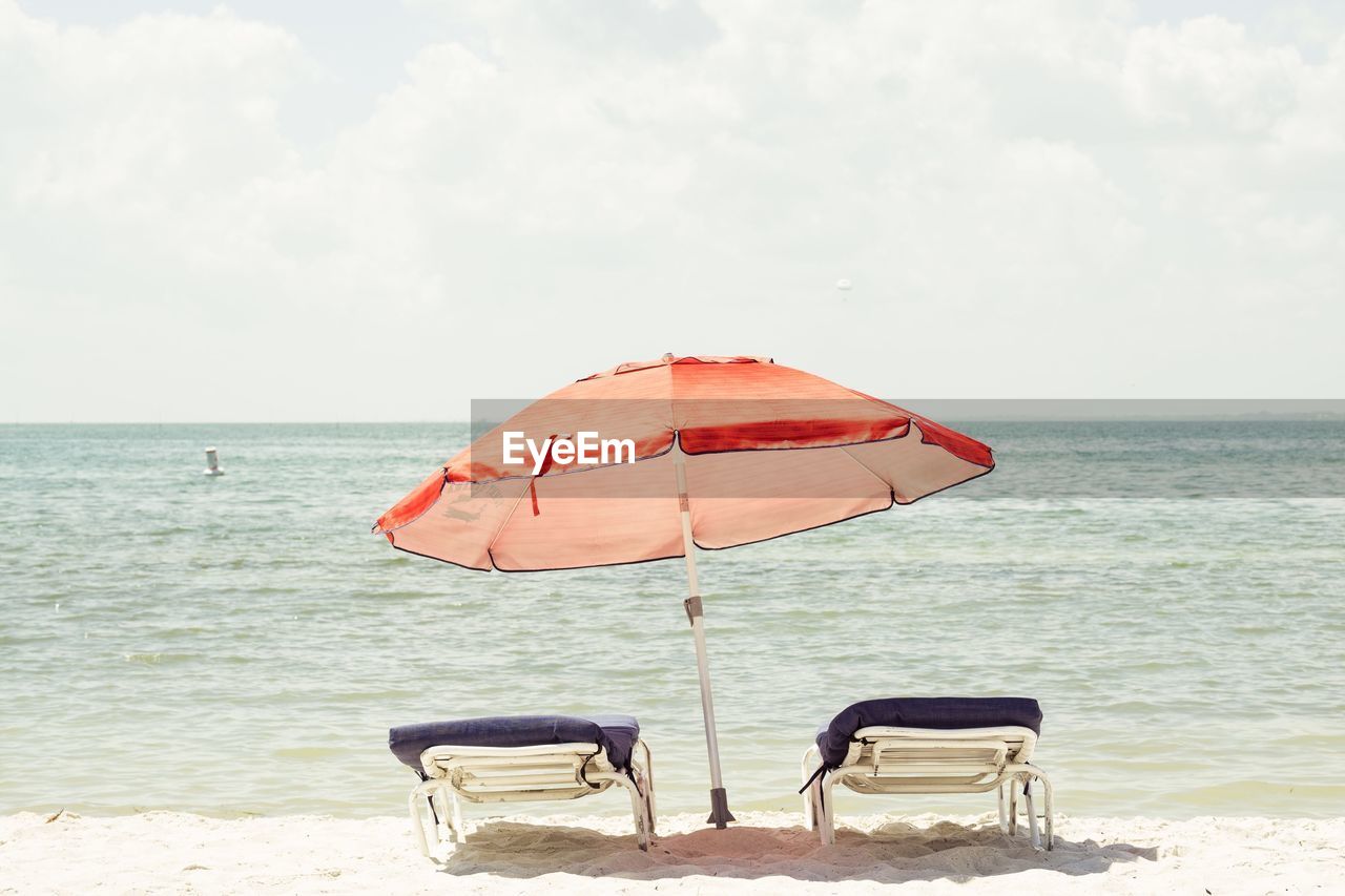 Scenic view of beach against cloudy sky