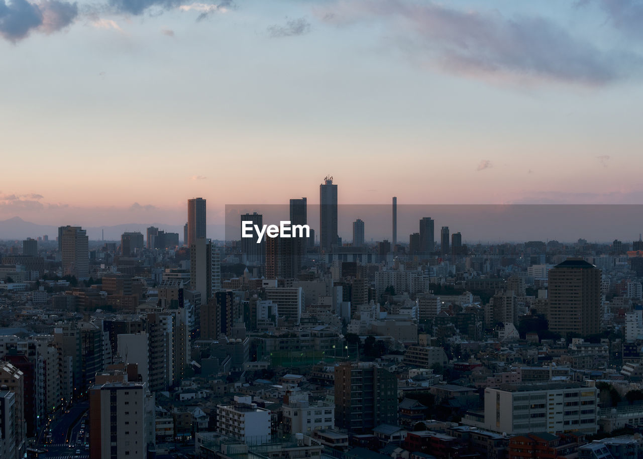 Aerial view of silhouette buildings against sky during sunset