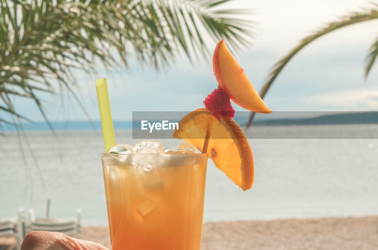 Close-up of planter's punch cocktail on beach