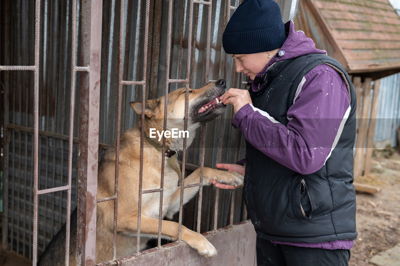 Girl volunteer in the nursery for dogs. shelter for stray dogs.