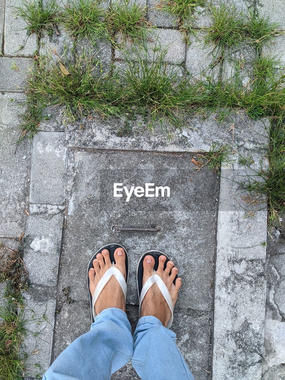 Low section of man standing on concrete floor