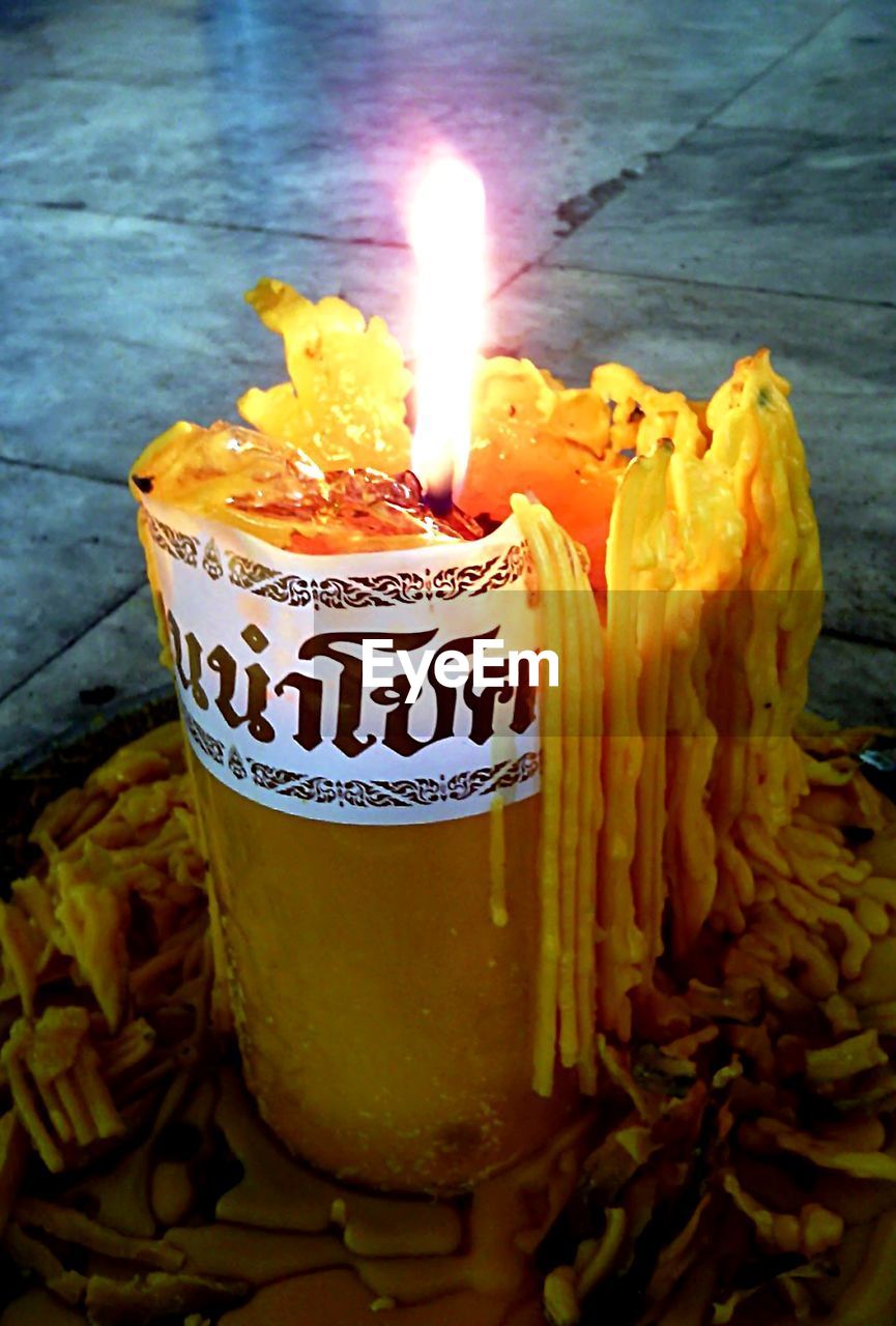 CLOSE-UP OF YELLOW CANDLES ON TABLE