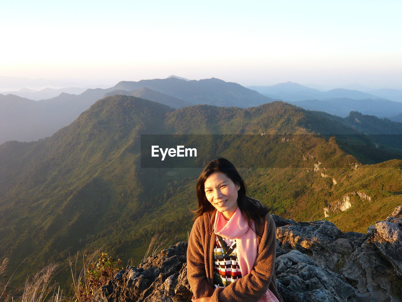 Portrait of smiling woman on mountain against sky