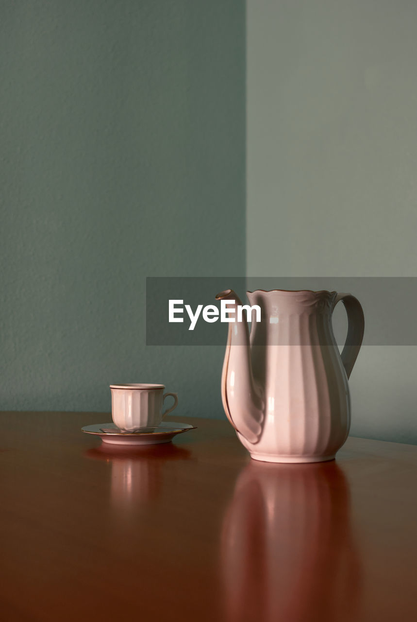 Coffee cup and teapot on a corner table. conceptual image