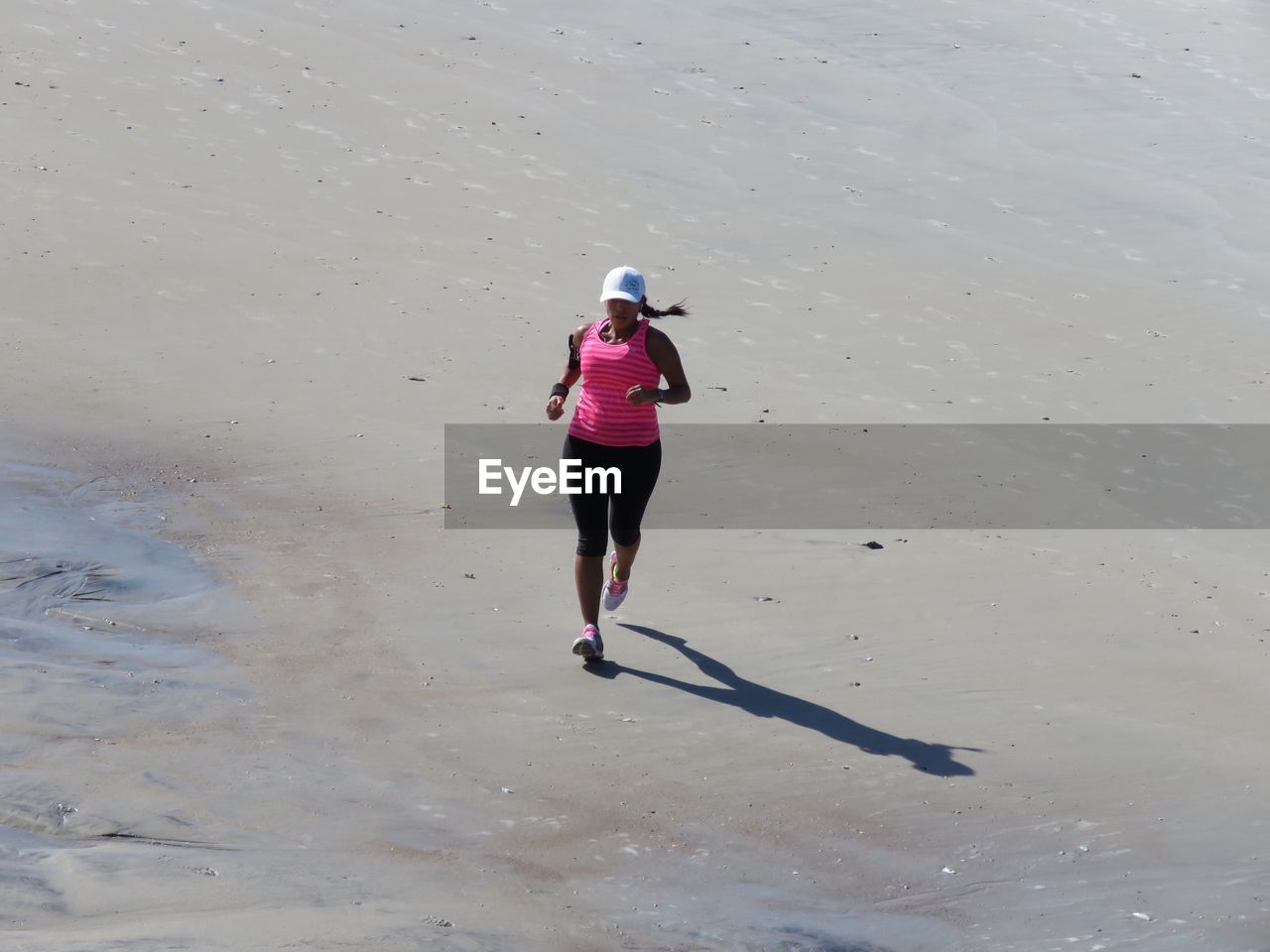 High angle view of woman jogging on sand at beach