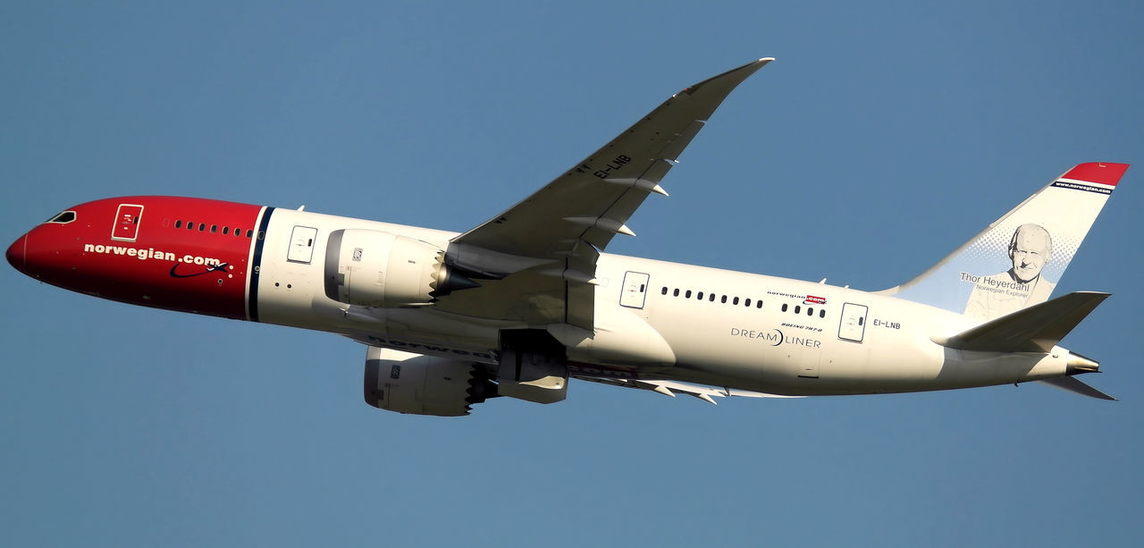 LOW ANGLE VIEW OF AIRPLANE FLYING OVER BLUE SKY