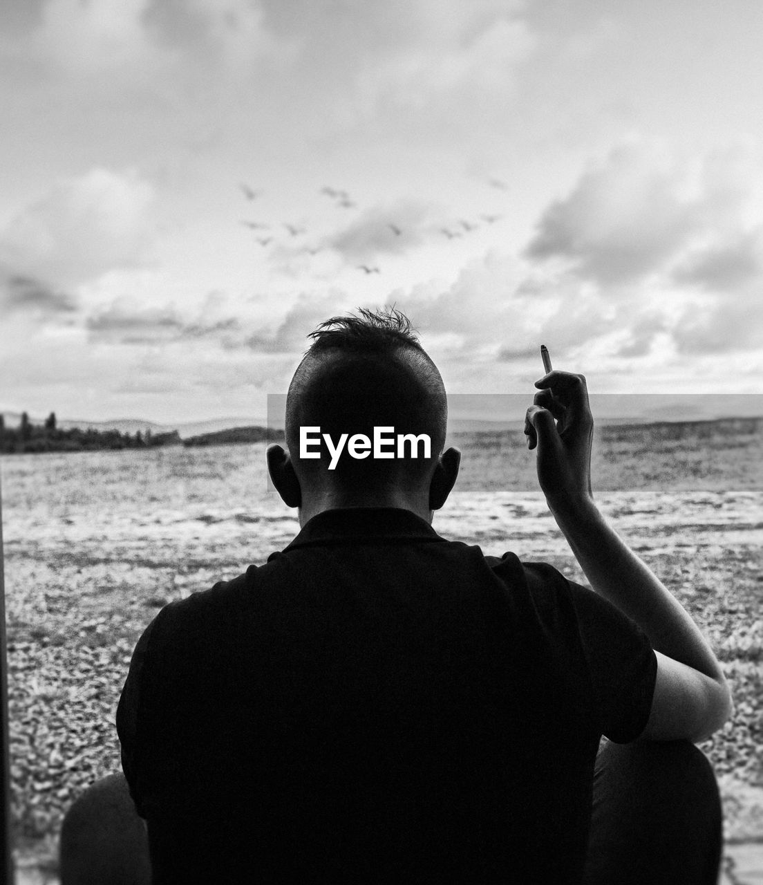 Rear view of man on beach against sky