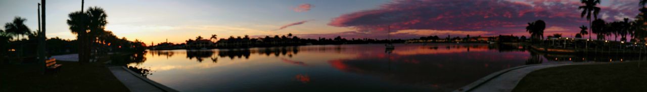 PANORAMIC VIEW OF SILHOUETTE TREES BY LAKE AGAINST ROMANTIC SKY