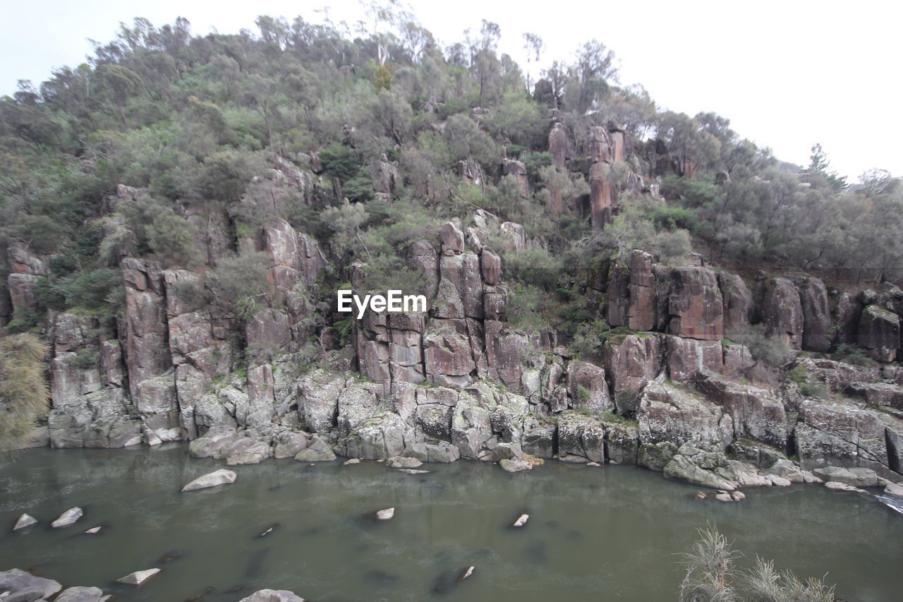 SCENIC VIEW OF ROCKS IN LAKE AGAINST SKY