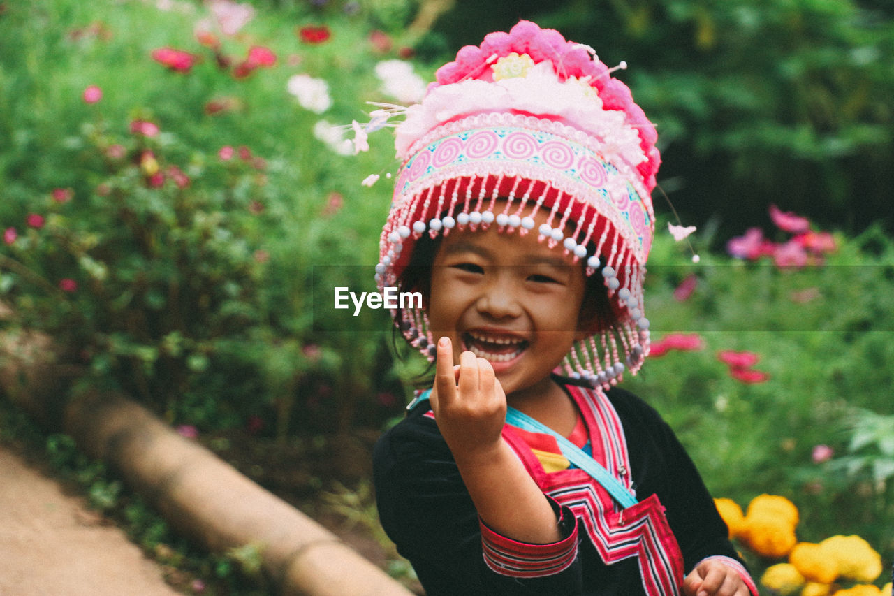 PORTRAIT OF A SMILING GIRL AGAINST BLURRED BACKGROUND