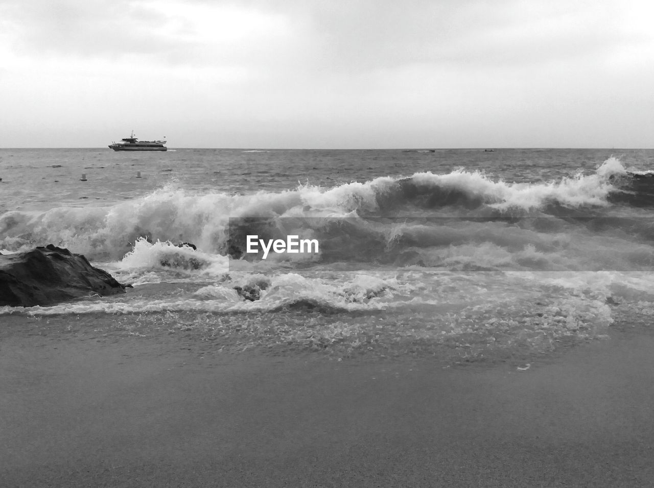 WAVES BREAKING ON BEACH AGAINST SKY