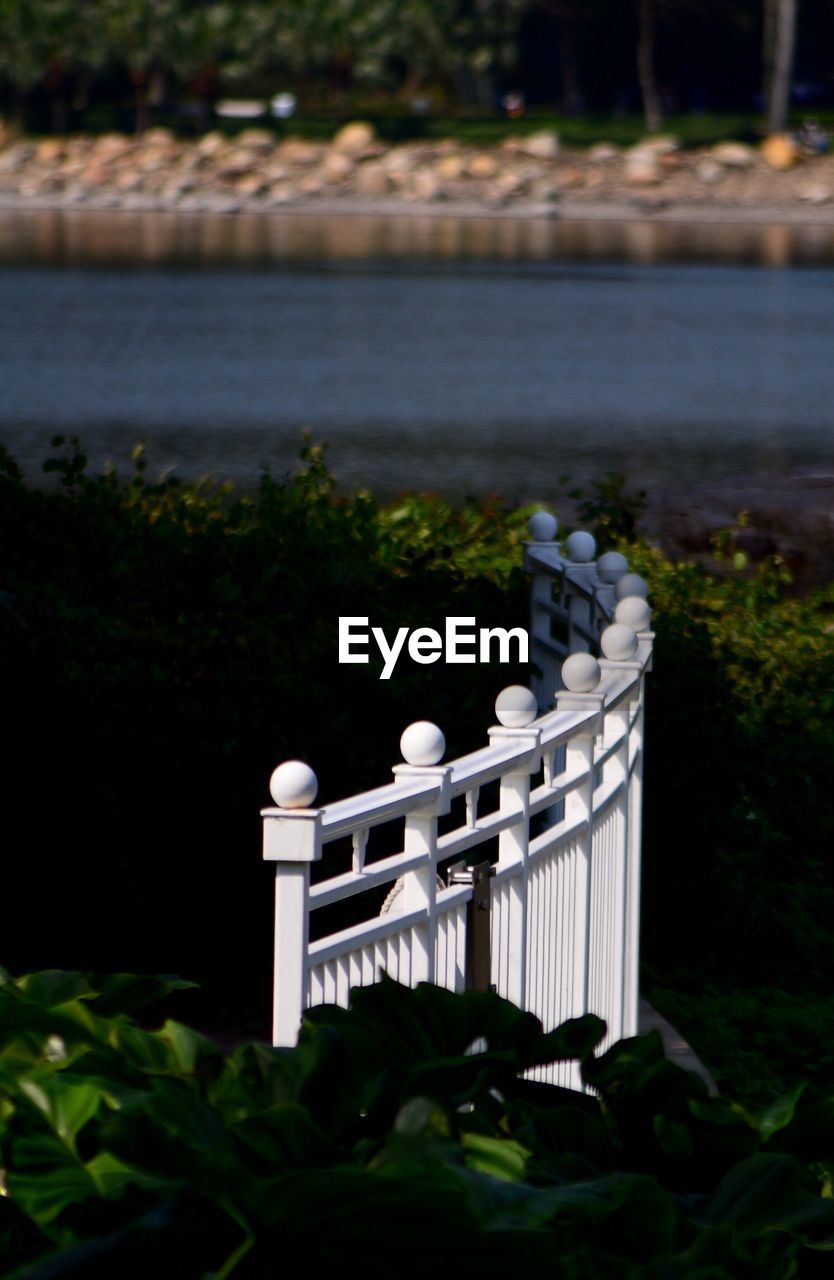 Close-up of railing against calm lake