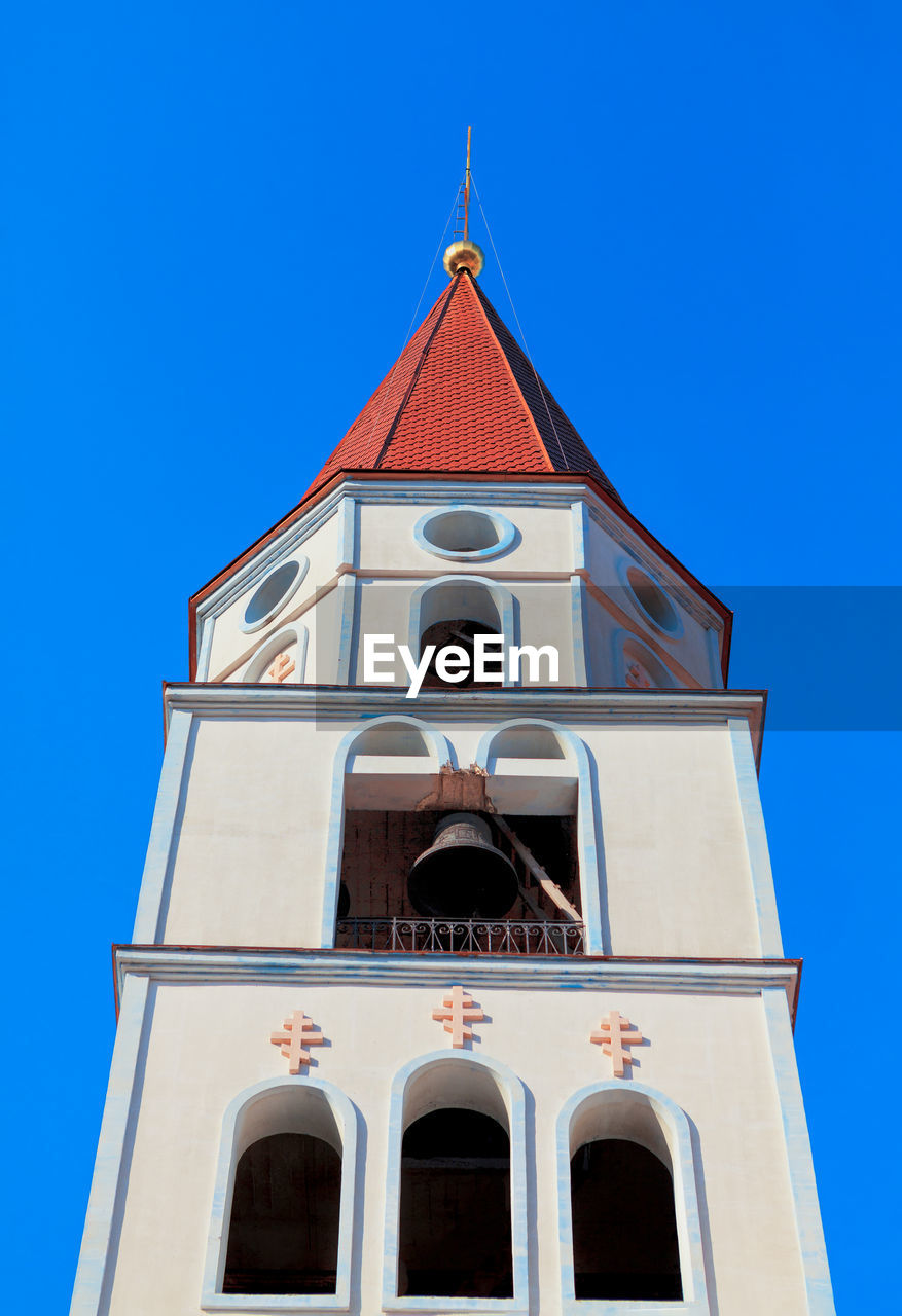 Bell tower with iron bell . steeple with red dome