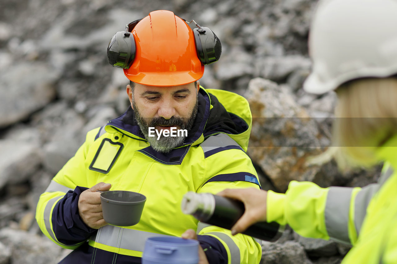 Engineers in reflective clothing having hot drink