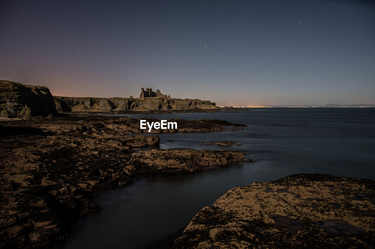 Scenic view of sea against clear sky at night