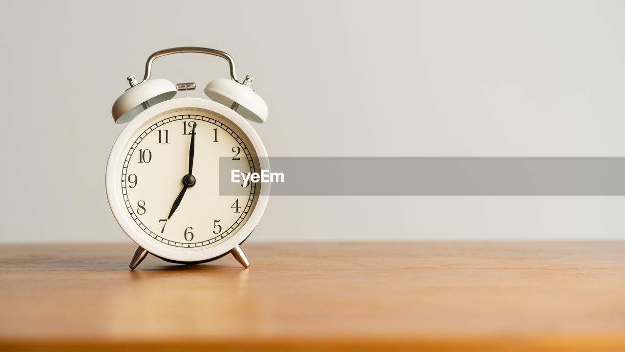 CLOSE-UP OF CLOCK ON TABLE