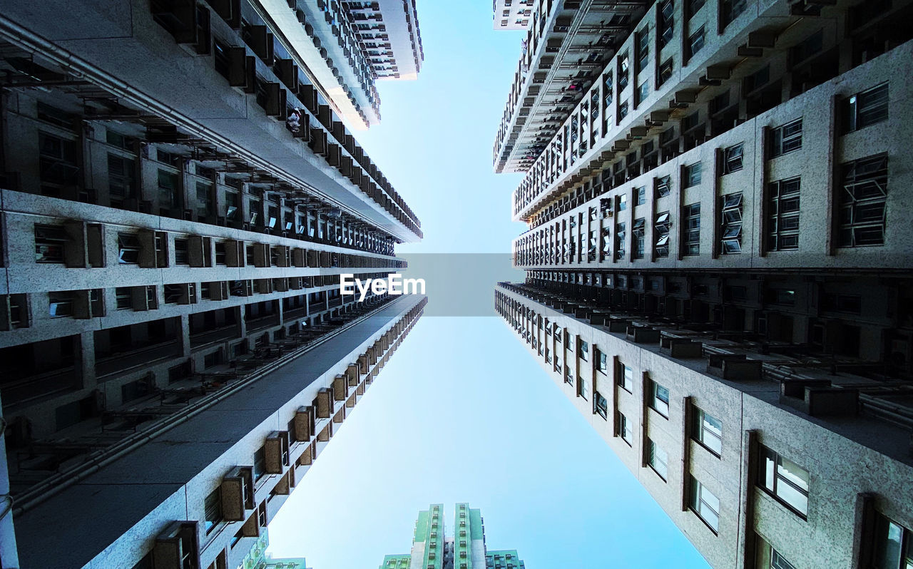 Directly below shot of buildings against clear sky