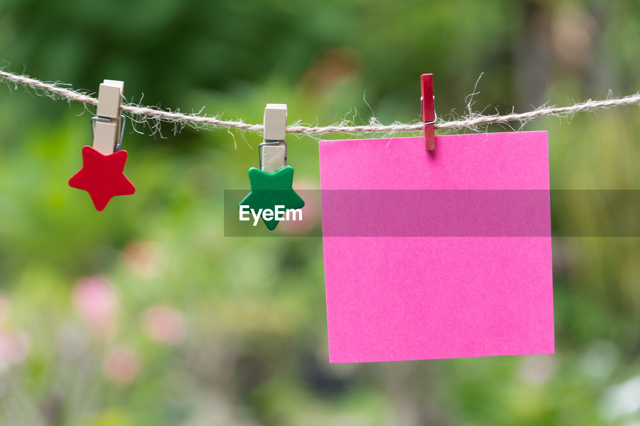 Close-up of adhesive note hanging on clothesline