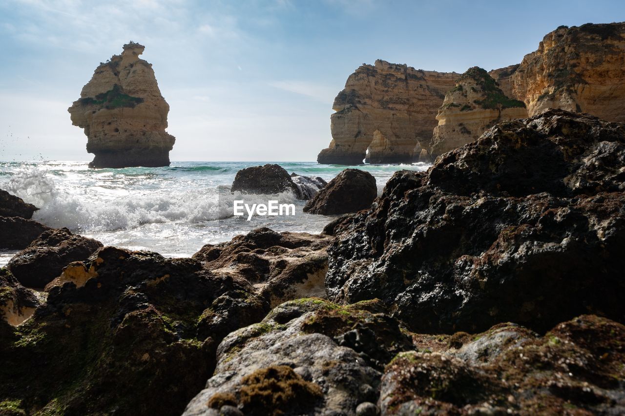 Scenic view of rocks in sea against sky