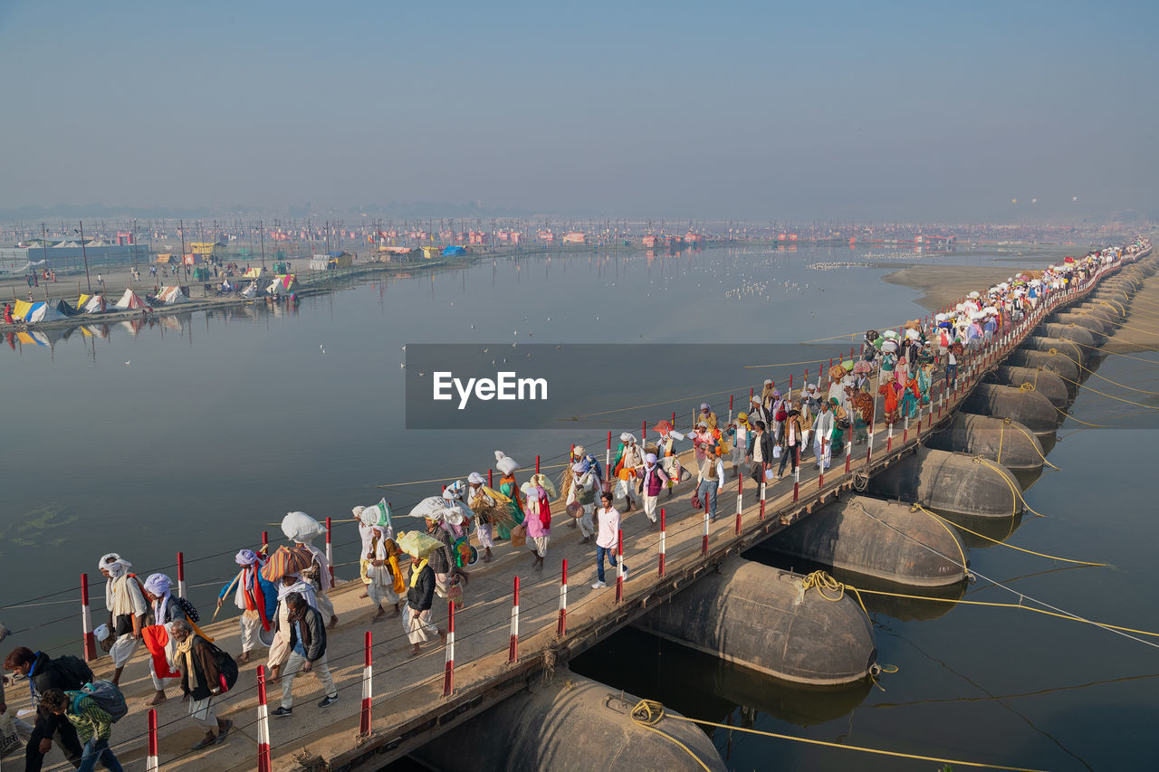 Crowd over river on footbridge