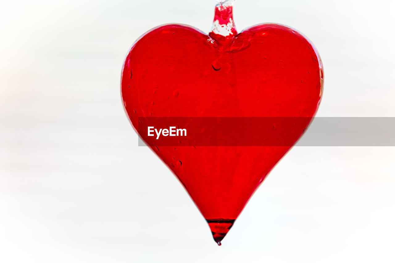 Close-up of red heart shape against white background