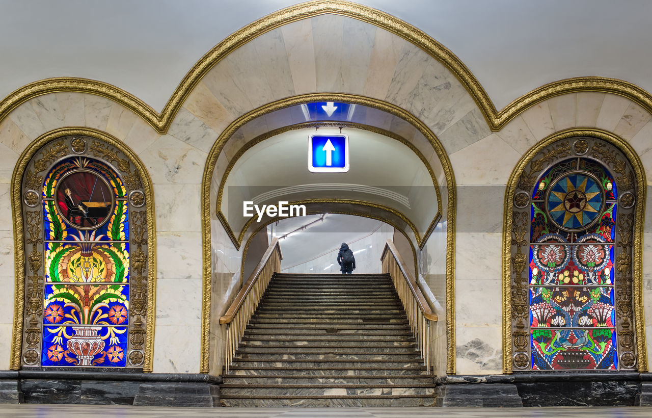 Illuminated arrow symbol over staircase at novoslobodskaya