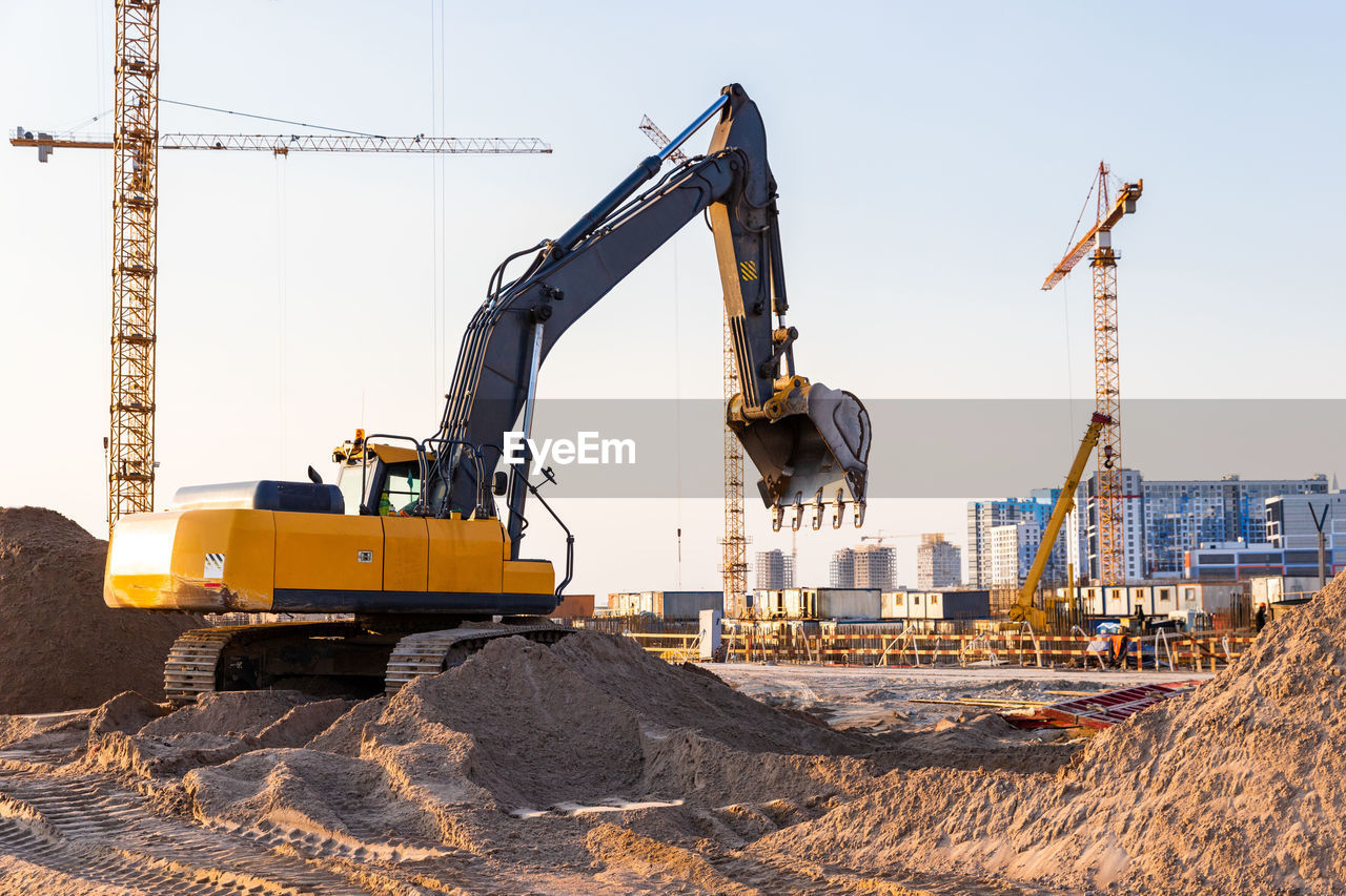 Cranes at construction site against sky