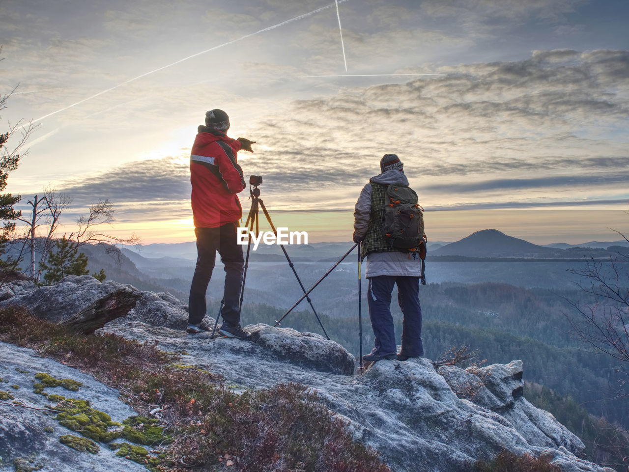 Nature travel photographers in red and light jacket taking photo of autumnal landscape