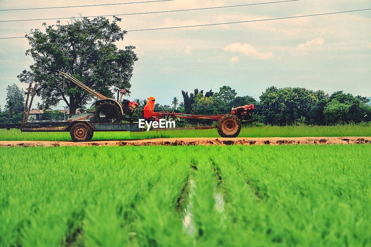 Tractor on agricultural field against sky