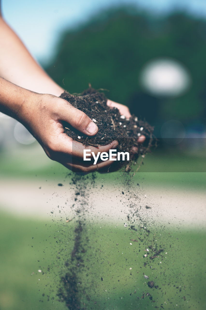 Cropped hand holding soil