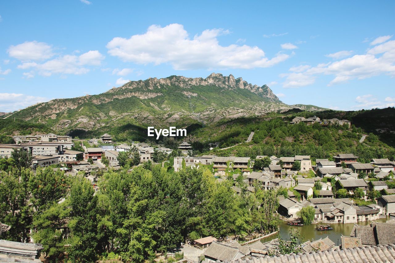 Scenic view of townscape and mountains against sky