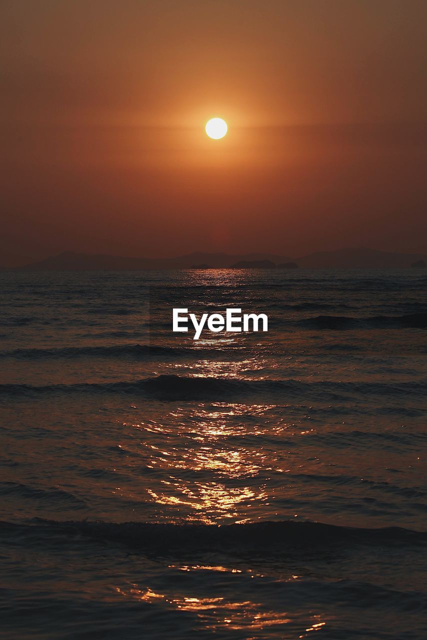 Scenic view of sea against orange sky