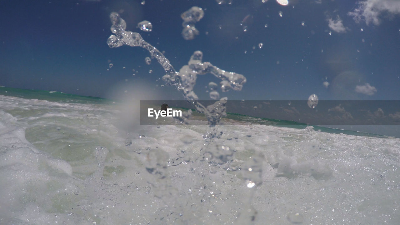 PEOPLE SPLASHING WATER IN SEA