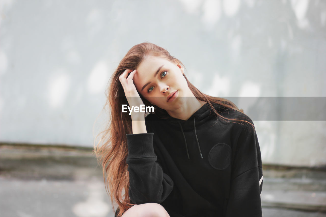 Portrait of beautiful young woman sitting outdoors