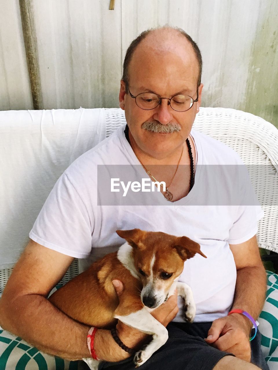 Man with dog sitting on sofa at home