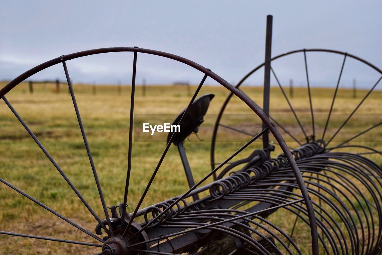 CLOSE-UP OF BARBED WIRE FENCE ON FIELD