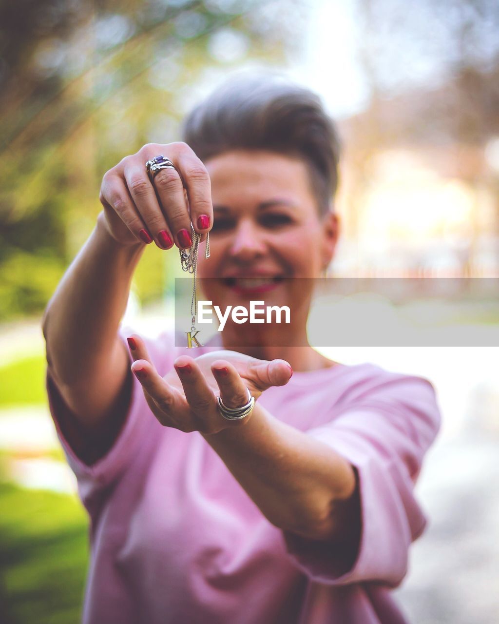 Mature woman holding k letter pendant