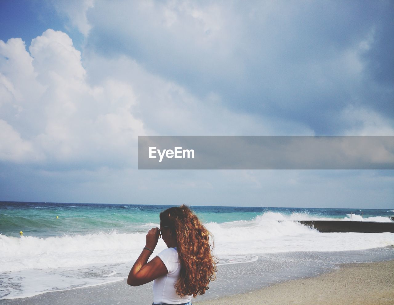 Woman at beach against sky