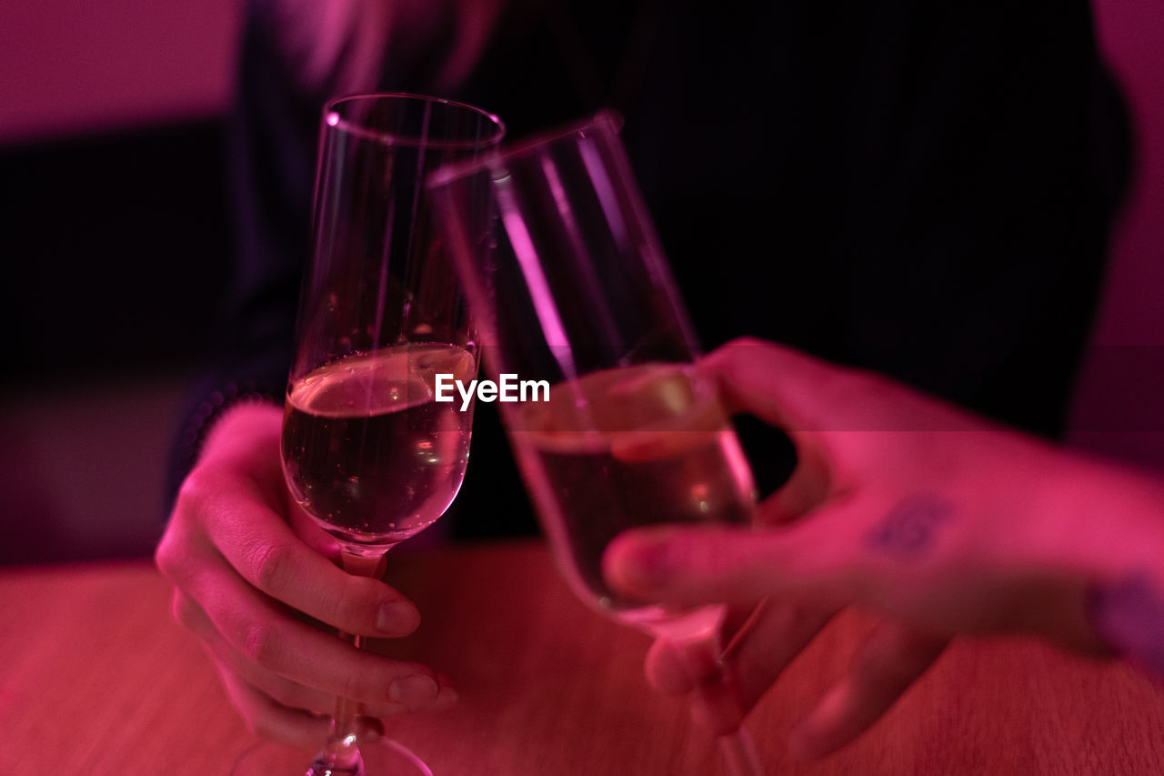 CLOSE-UP OF HAND HOLDING WINE GLASSES