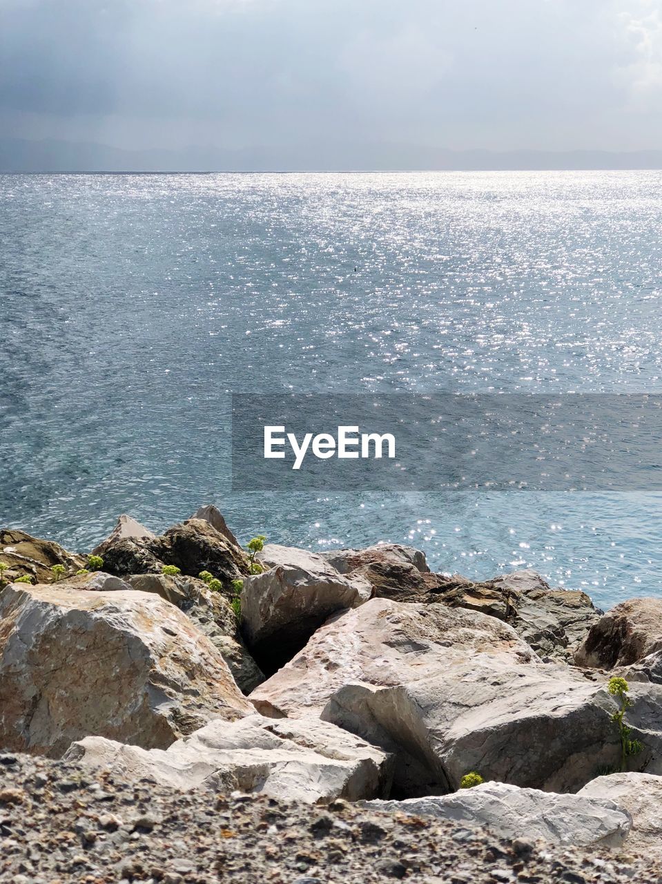 ROCKS ON SHORE AGAINST SKY