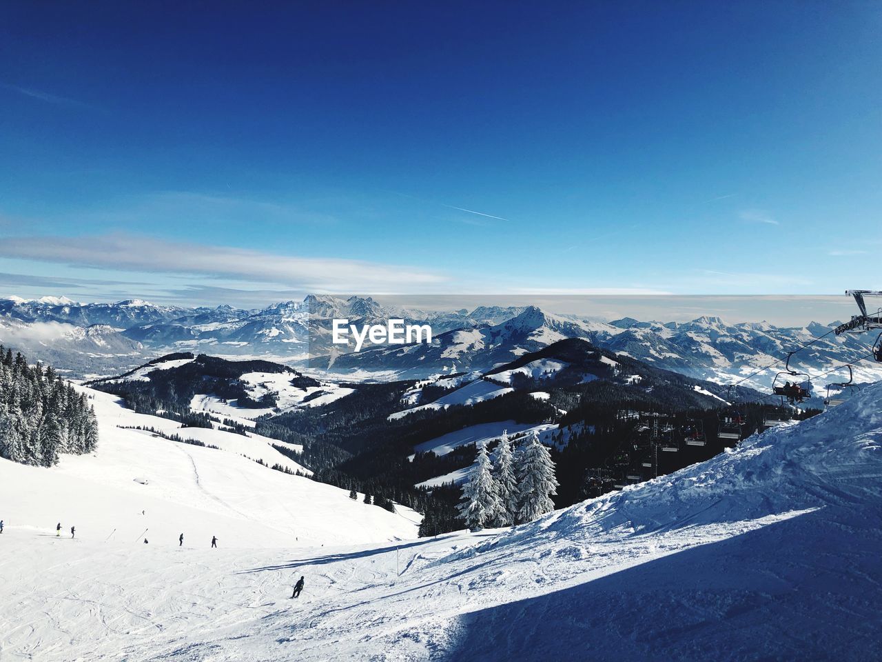 Scenic view of snow covered mountains against blue sky