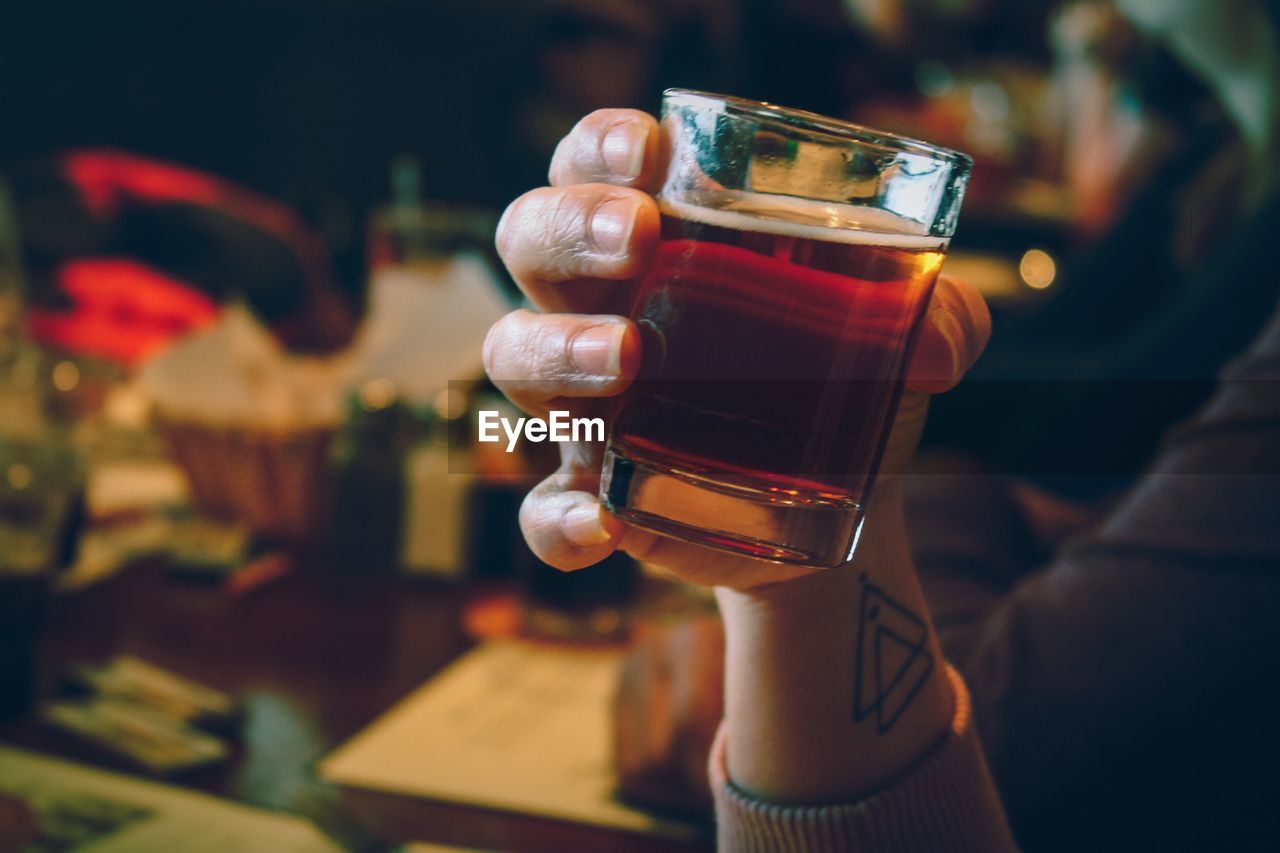 Close-up of woman hand holding alcoholic drink in bar