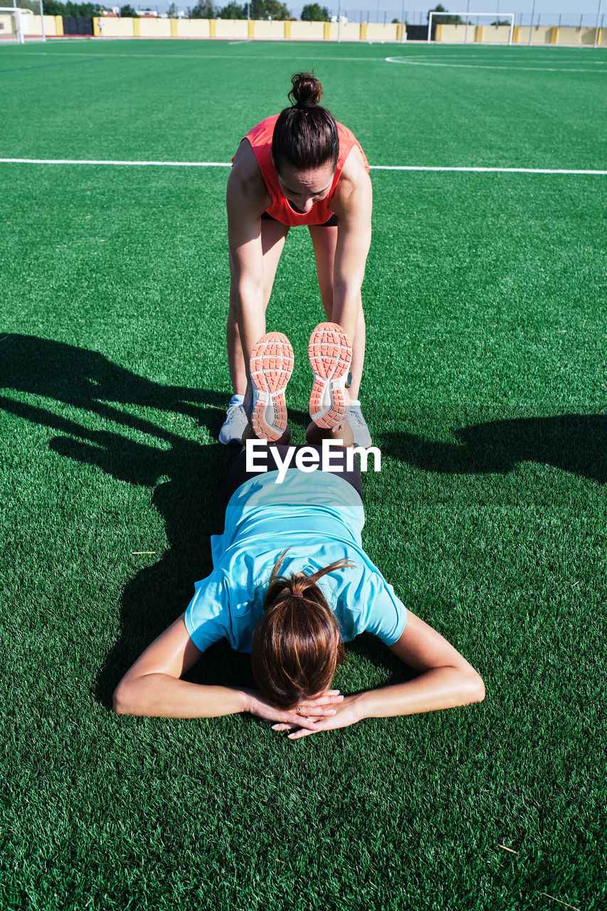 Two women help each other practice their stretching