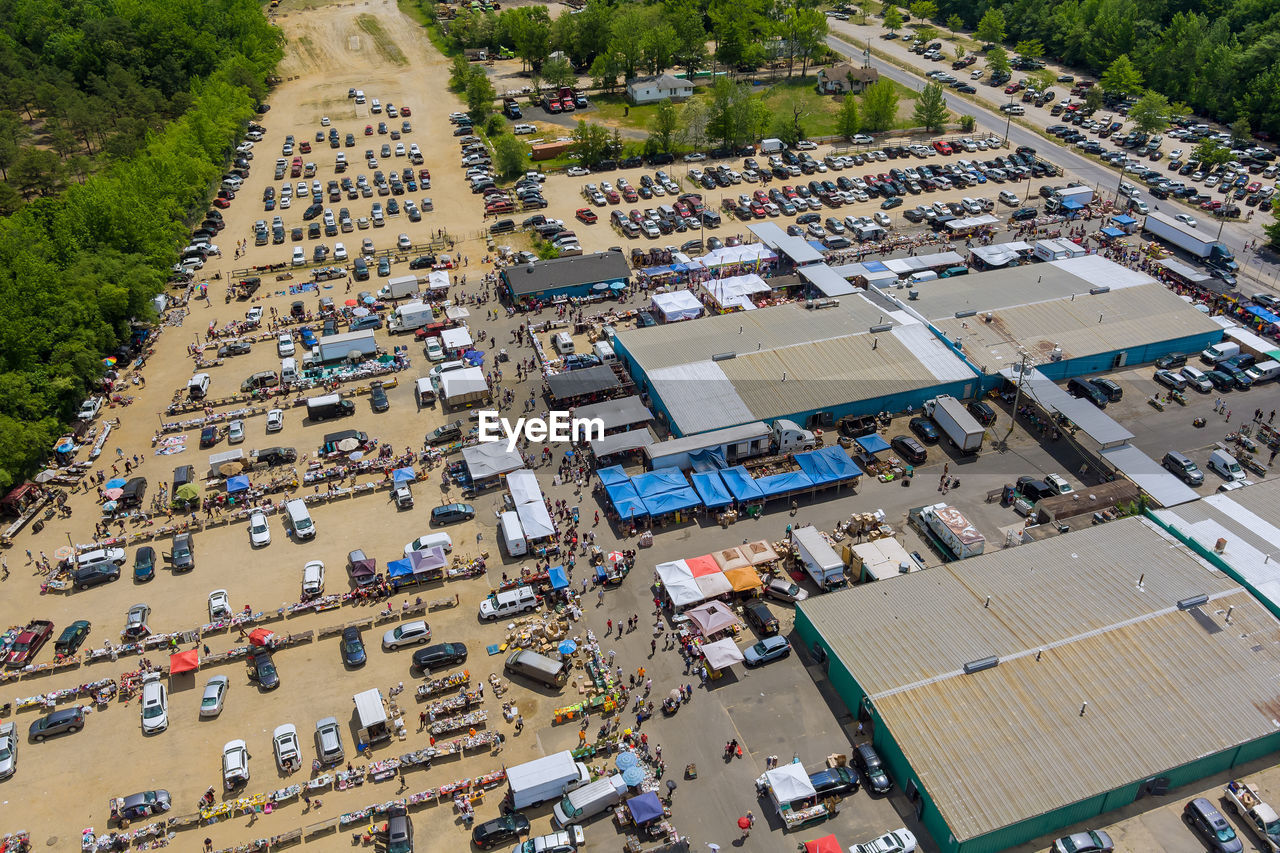 HIGH ANGLE VIEW OF CARS ON ROAD BY BUILDINGS